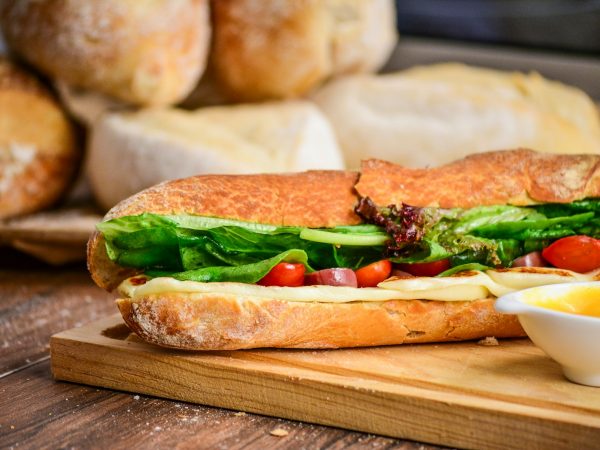 baked bread with vegetable on brown chopping board